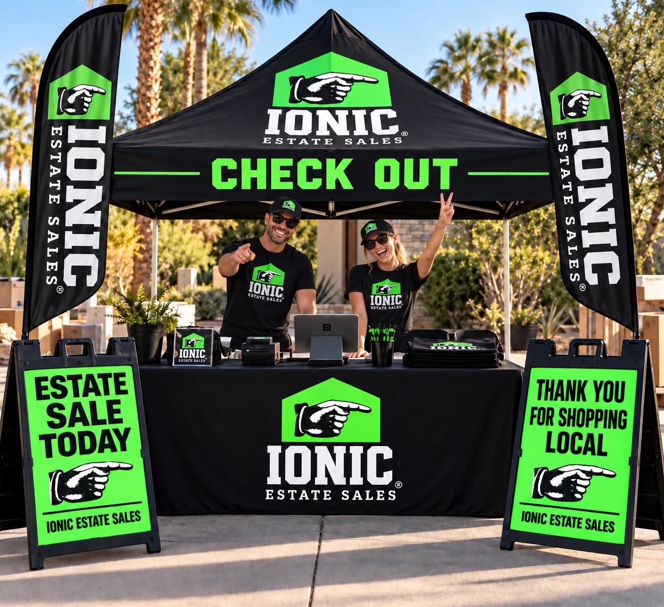 Ionic Estate Sales branded pop-up check-out tent with two team members at an outdoor sale